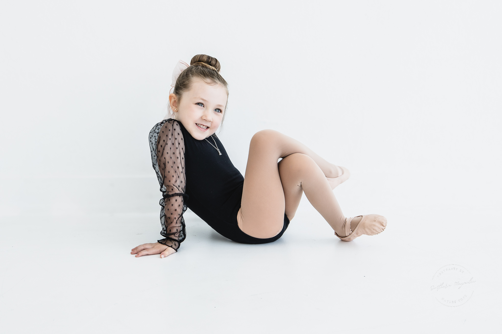 A young Chickasha School of Dance student in a black leotard during a studio portrait session