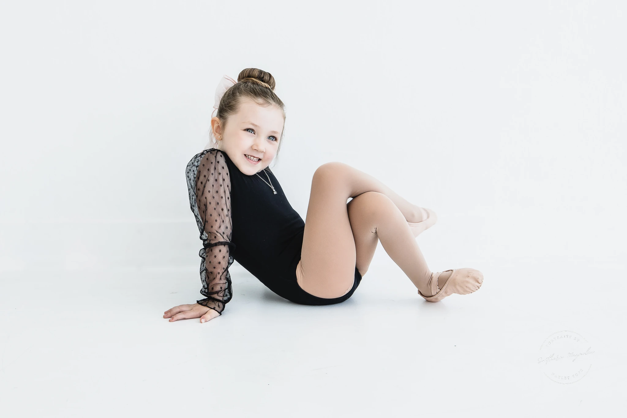 A young Chickasha School of Dance student in a black leotard during a studio portrait session